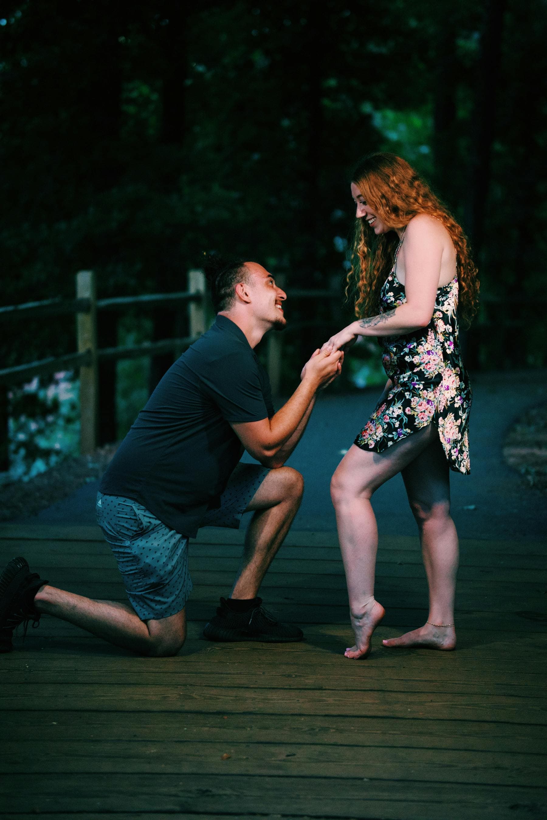 Couple celebrating an engagement in a scenic outdoor setting.