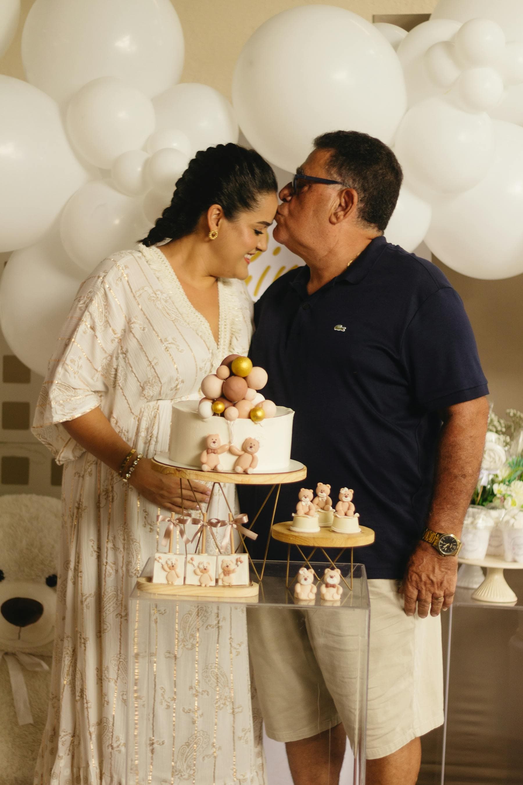 Expecting couple posing with baby shower decorations.